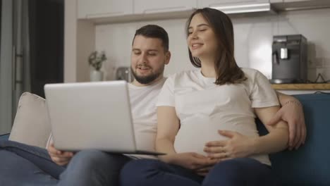 Schöne-Schwangere-Frau-Und-Mann,-Die-Sich-Einen-Comedy-Film-Auf-Dem-Laptop-Ansehen