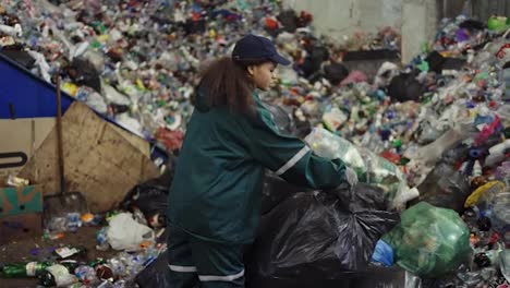 Afroamerikanische-Frau-Sortiert-Müllsäcke-In-Einer-Recyclinganlage.-Umweltschutz