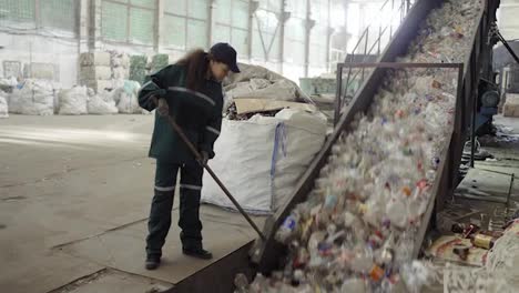 A-young-African-American-woman-checks-a-conveyor-belt-at-a-recycling-plant.-Pollution-control