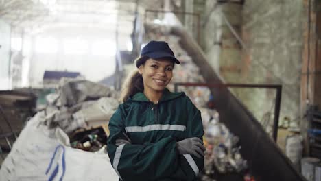 Porträt-Einer-Jungen-Afroamerikanischen-Frau,-Die-Ein-Förderband-In-Einer-Recyclinganlage-überprüft.-Umweltschutz