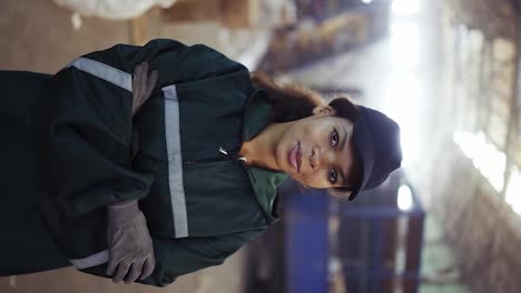 portrait-of-and-African-American-woman-in-a-special-green-uniform-against-the-background-of-the-interior-of-a-waste-processing