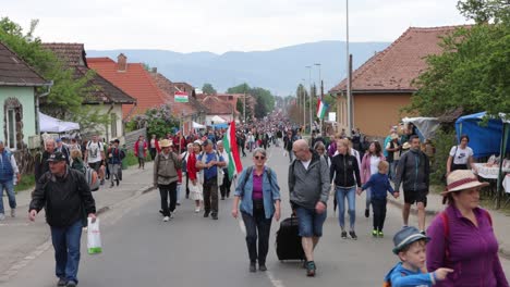 Diverse-crowd-of-people-walk-towards-camera-up-street-on-Csiksomlyo-Pilgrimage