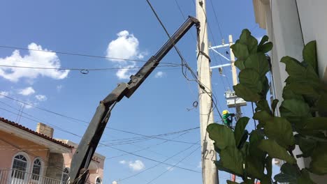 Crane-lifting-broken-concrete-power-utility-pole-on-busy-street,-Tuxpan,-Mexico