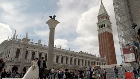 Wedding-Couple-Getting-Photos-Done-At-Piazza-San-Marco-With-Bell-Tower-In-Background-In-Venice