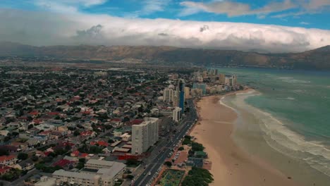 established-Aerial-shot-of-Cape-Town-city-and-beach-view,-Cityscape-and-dramatically-weather,-Shoreline-of-Camps-Bay,-Twelve-Apostles-Mountains