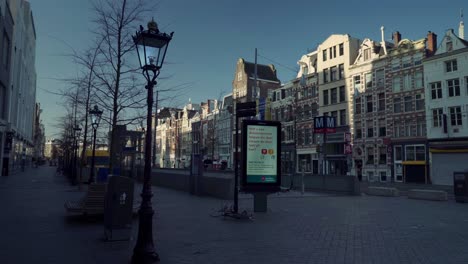 Empty-streets-of-Rokin-in-Amsterdam,-Keep-your-distance-on-roadside-digital-advertising-monitor-during-the-covid19-lockdown,-gimbal-shot