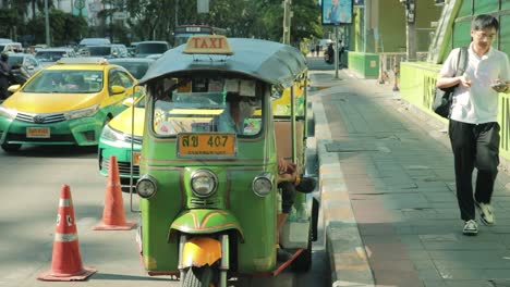 Grüner-Tuk-Tuk-Taxifahrer-Wartet-Auf-Dem-Bürgersteig-In-Bangkok,-Thailand