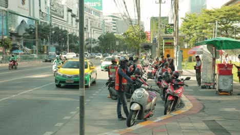 Thai-Motorcycle-Taxis-Waiting-for-Passengers-at-a-Bus-Stop-in-Bangkok,-Thailand