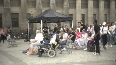 Vibrant-atmosphere-as-people,-including-kids,-elderly,-and-families,-gather-at-Edinburgh-City-Center-on-a-warm,-sunny-day,-enjoying-a-captivating-concert
