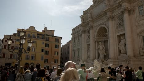 Trevi-Fountain-On-Sunny-Day-Viewed-From-Via-della-Stamperia-As-Tourists-Walk-By
