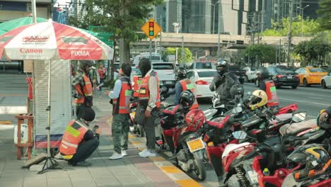 Thai-Motorcycle-Taxis-Waiting-for-Passengers-at-a-Bus-Stop-in-Bangkok,-Thailand