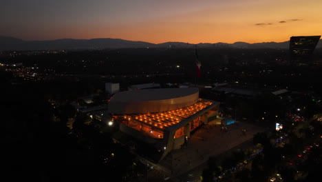 Aerial-view-around-the-illuminated-Auditorio-Nacional,-vibrant-dusk-in-Mexico-city