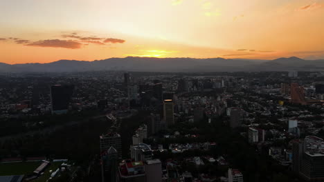 Aerial-view-backwards-over-the-Polanco-district,-colorful-sundown-in-Mexico-city