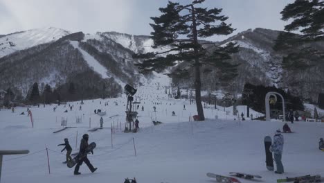 A-timelapse-frame-capturing-the-bustling-atmosphere-of-Hakuba-ski-resort-under-the-bright-daylight,-as-skiers-gracefully-descend-the-slopes