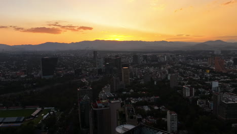 Aerial-view-rising-over-the-cityscape-of-Polanco,-colorful-dusk-in-Mexico-city