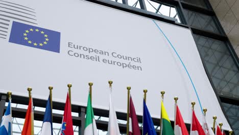 A-view-of-the-EU-banner-inside-the-European-Council-Justus-Lipsius-building-in-Brussels,-Belgium---Panning-shot