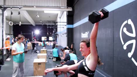 Grit-and-Strength:-Brunette-Girl-with-Pigtails-Pushing-Through-Snatches-in-CrossFit-Competition,-Background-Features-Other-Competitors