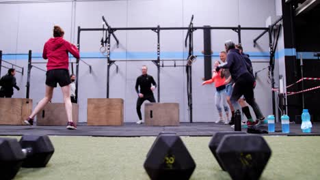 Dynamic-Warm-up:-Athletes-Performing-Side-Steps-Around-Jump-Boxes,-with-Pull-Up-Bars-in-the-Background