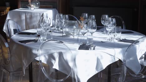 Sunlit-Slow-Motion-Shot-of-a-Well-Set-Fine-Dining-Table-with-White-Cloth