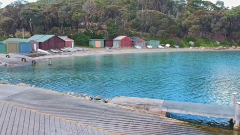 Pirates-Bay,-Tasmania,-Australia---12-March-2019:-The-boat-sheds-boat-ramp-and-boats-on-the-shore-of-Pirates-Bay-Tasmania,-Australia