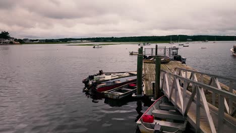 Pine-Point-Marina-with-dock-leading-to-small-boats-with-calm-waters-and-dark-clouds