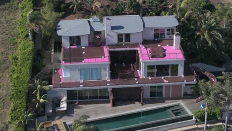 Barbie-Dream-house-from-movie-in-Malibu-under-renovation,-aerial-rising-view-during-the-day
