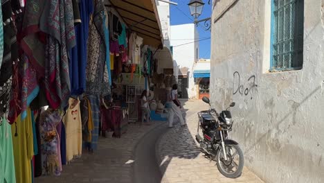 Colorful-shops-and-tourists-at-Houmt-El-Souk-market-in-Djerba,-Tunisia