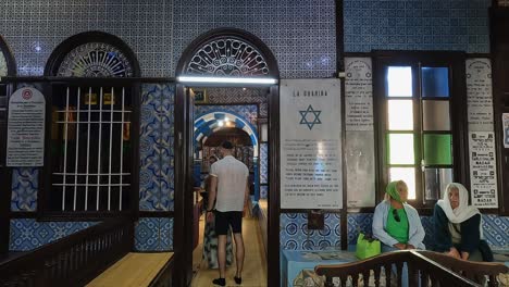 Tourists-at-El-Ghriba-Jewish-synagogue-of-Djerba-in-Tunisia-in-summer-season-with-Jewish-Star-of-David-symbol-on-wall