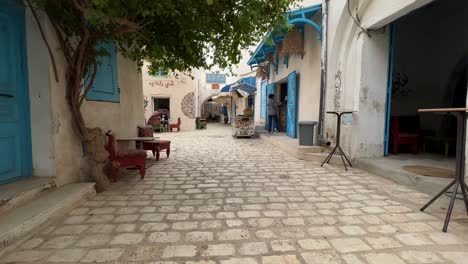 Personal-perspective-walking-along-Houmt-El-Souk-market-streets-in-Djerba,-Tunisia