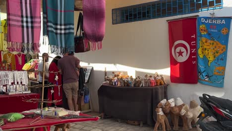 Tunisian-city-life-at-traditional-shops-of-Houmt-El-Souk-market-in-Djerba,-Tunisia