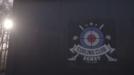 Curling-club-Zemst-logo-on-building-with-sunshine-flair