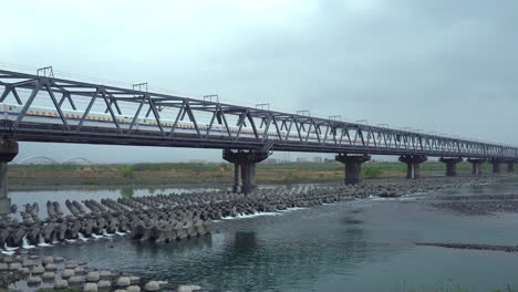 SHIZUOKA,-JAPAN---APRIL-6,-2023:-Tokaido-Shinkansen-crossing-Fuji-View-Shinkansen-rail-bridge-in-the-evening