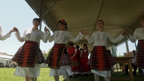 Fröhliche-Menschen-Tanzen-Bulgarisches-Horo-Unter-Einem-Schattigen-Zelt-Beim-Sommerfest