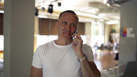 Adult-male-businessman-in-a-white-shirt-communicates-on-the-phone-and-discusses-important-things