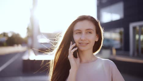 Happy-woman-talking-on-mobile-phone-outdoor,-lens-flares-on-background,-slow-motion
