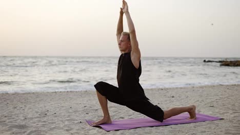 Ein-Junger-Mann-Praktiziert-Yoga,-Während-Er-Im-Morgengrauen-Auf-Einer-Sportmatte-Steht.-Eine-Bestimmte-Übung-Durchführen.-Körperdehnung.-Freizeit,-Ruhe