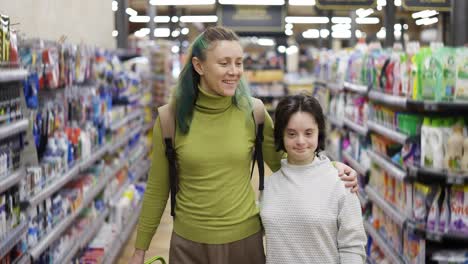 Portrait-of-Down-syndrome-cheerful-girl-with-her-mother-in-supermarket