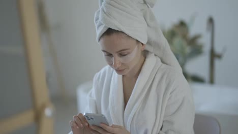 Kaukasische-Langhaarige-Frau,-Die-In-Der-Badewanne-Sitzt-Und-Ihr-Mobiltelefon-Benutzt