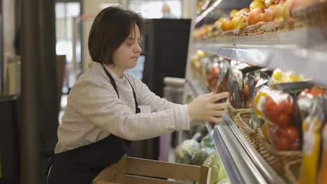 Female-worker-with-Down-syndrome-restocking-vegetables-from-the-box