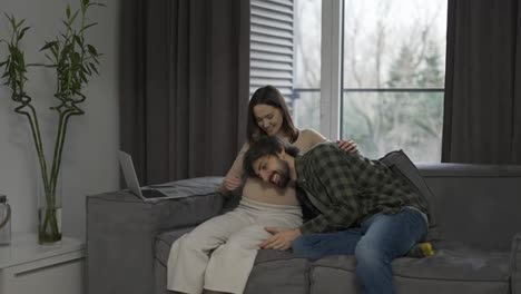 Pregnant-woman-with-large-belly-and-husband-close-to-it-waiting-for-movements