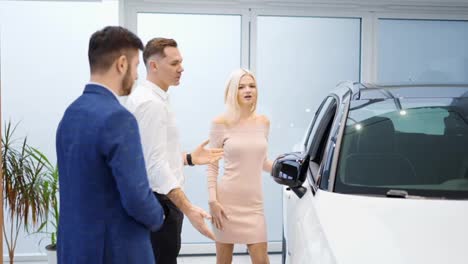 Pretty-young-elegant-couple-choosing-car-in-dealership