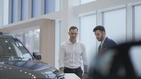 A-salesman-showing-the-new-car-model-to-a-client