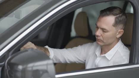 Man-sitting-inside-vehicle-in-car-dealership