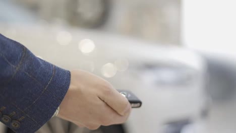 Man-hand-open-the-car-with-car-remote-key-at-car-showroom