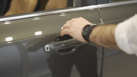 Close-up-of-man's-hand-opening-car-door.-Auto-business,-car-sale,-technology-and-people-concept