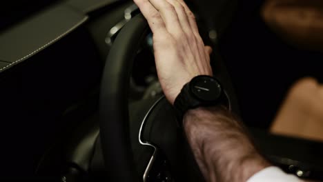Cropped-view-of-man-touching-steering-wheel-in-luxury-car