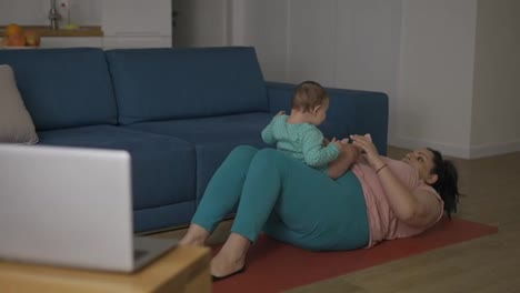 Overweight-woman-doing-exercises-online-with-little-baby-together