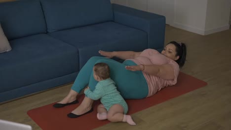 Übergewichtige-Frau-Macht-Bauchübungen,-Während-Ihr-Baby-Neben-Ihr-Spielt