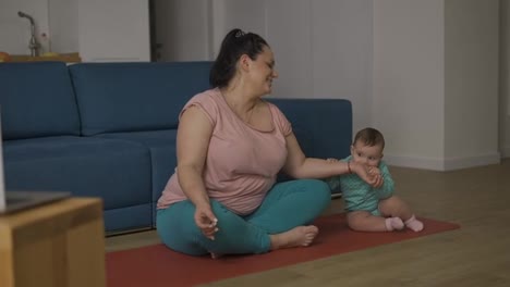 Plus-size-woman-disturbed-by-her-baby-while-sitting-on-the-floor-in-meditation