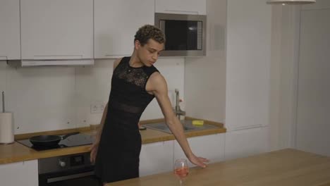A-transsexual-man-in-a-black-dress-dancing-around-on-the-home-kitchen